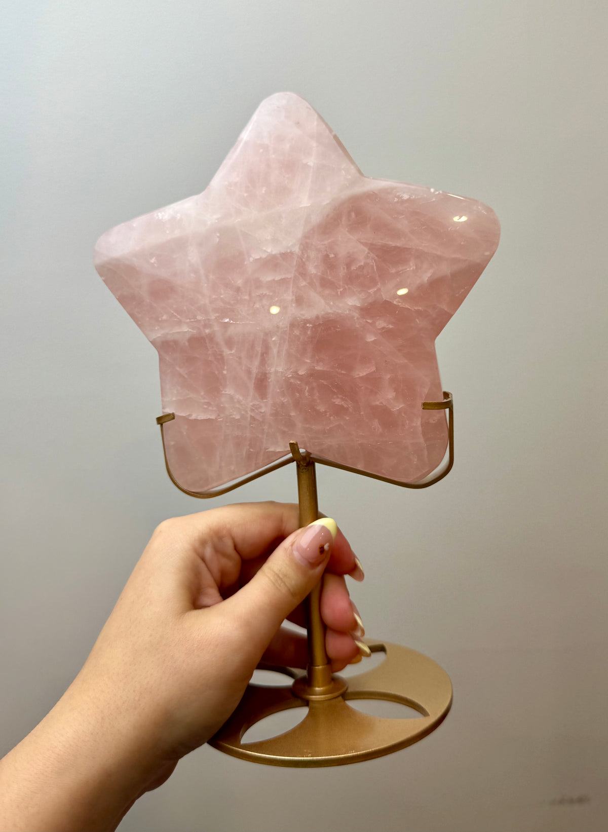Giant rose quartz star carving on a stand