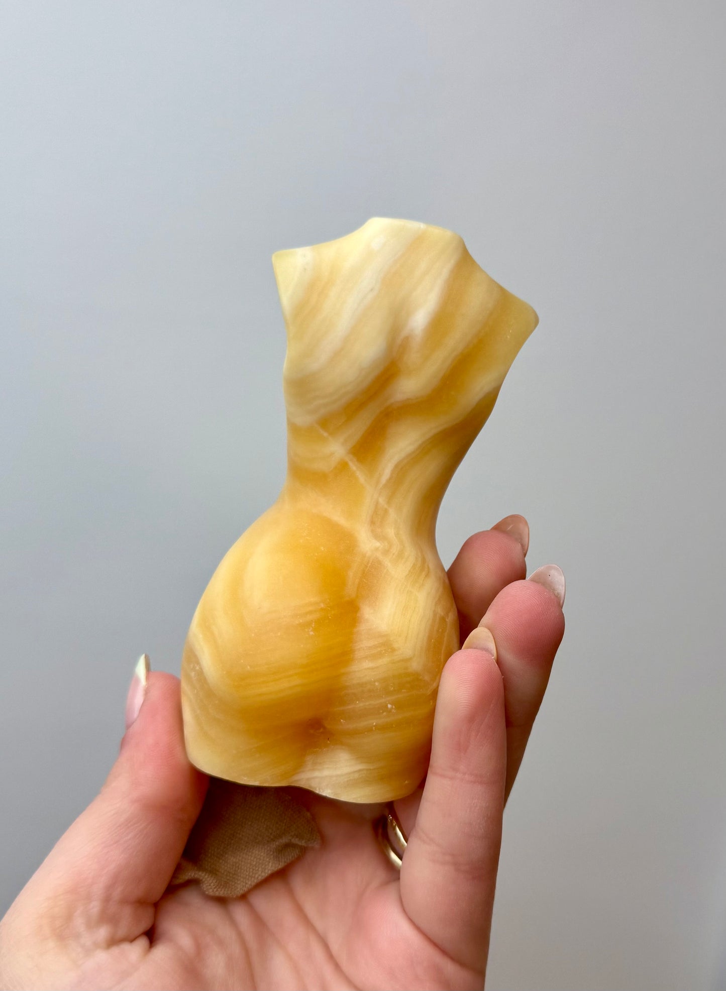 Orange calcite woman body carving