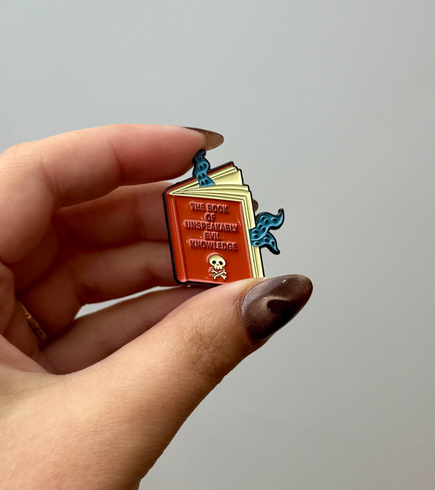 Unspeakable evil book enamel pin 