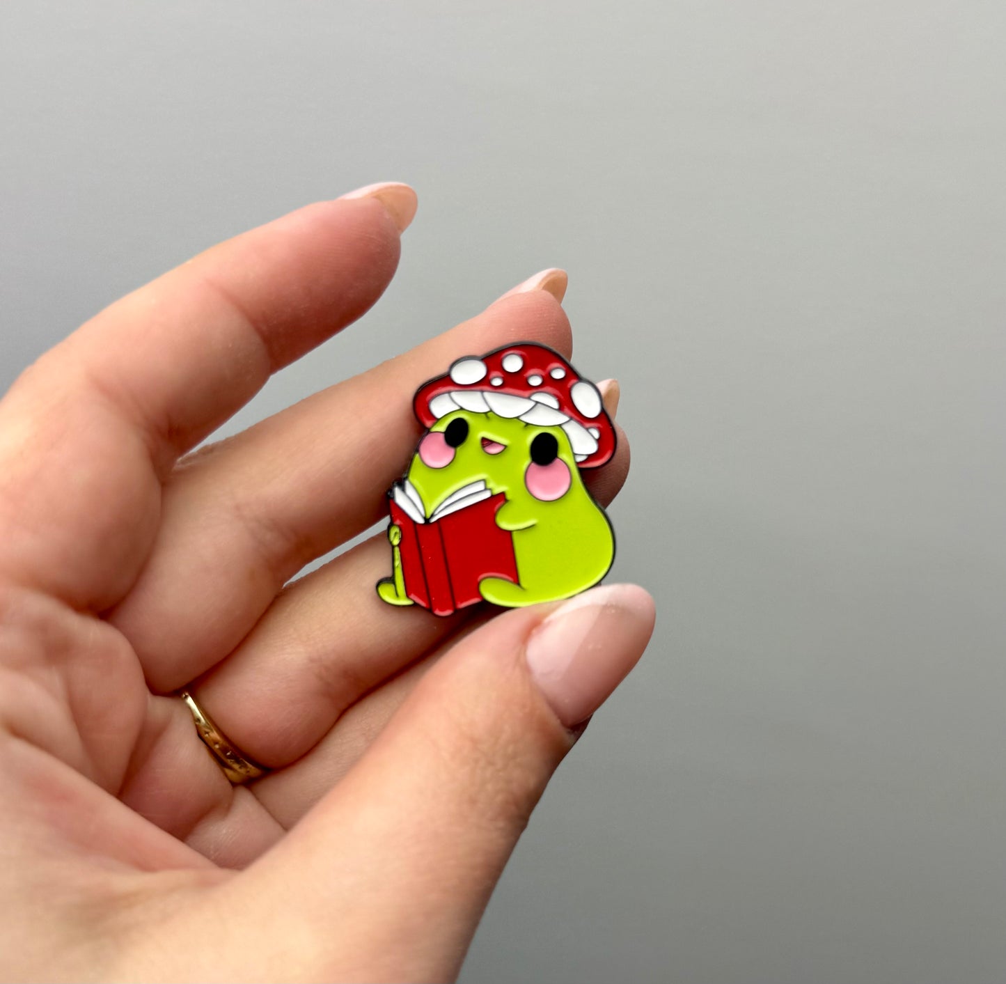 Frog reading a book enamel pin