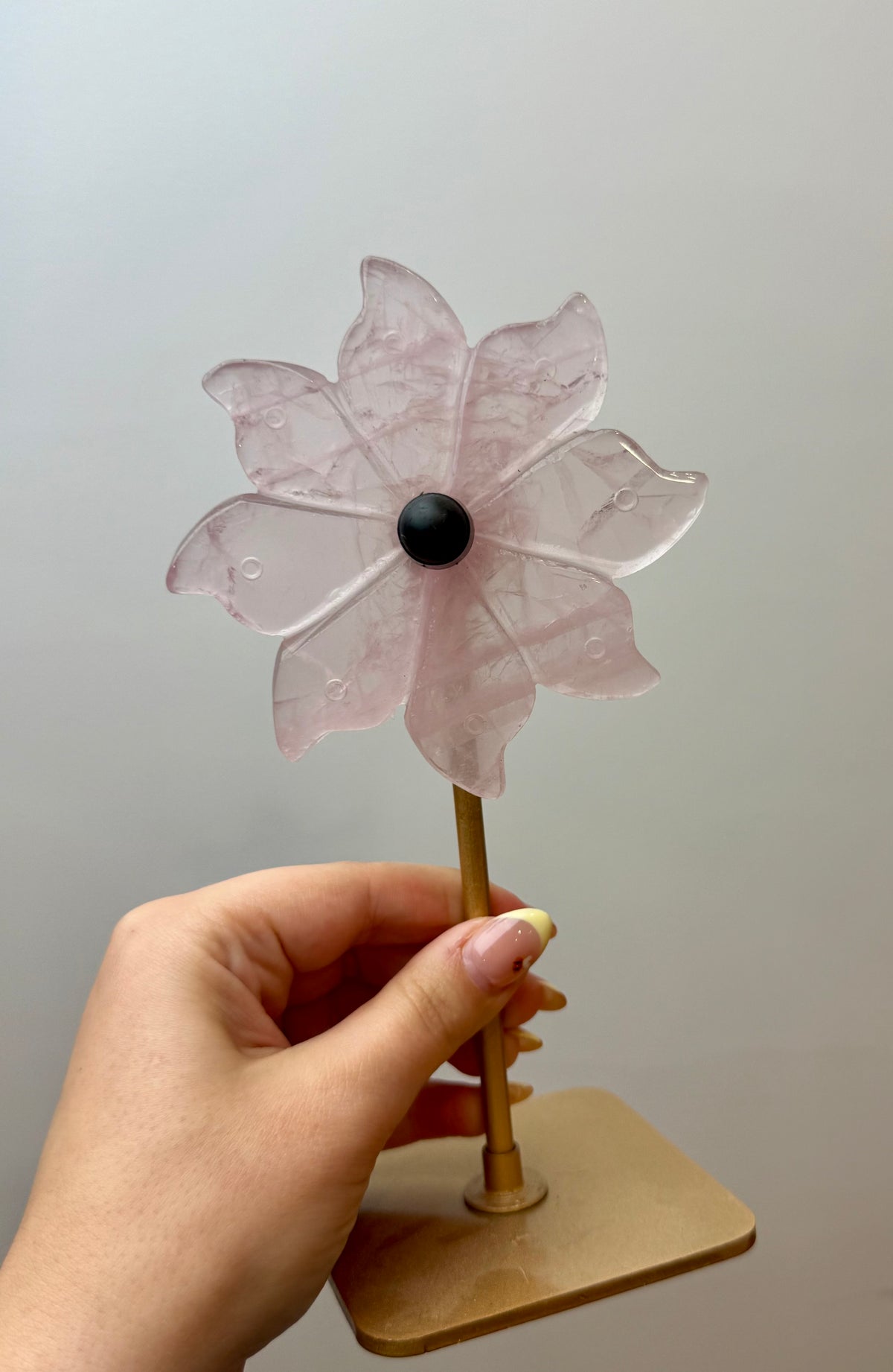 Rose quartz spinning flower carving on stand