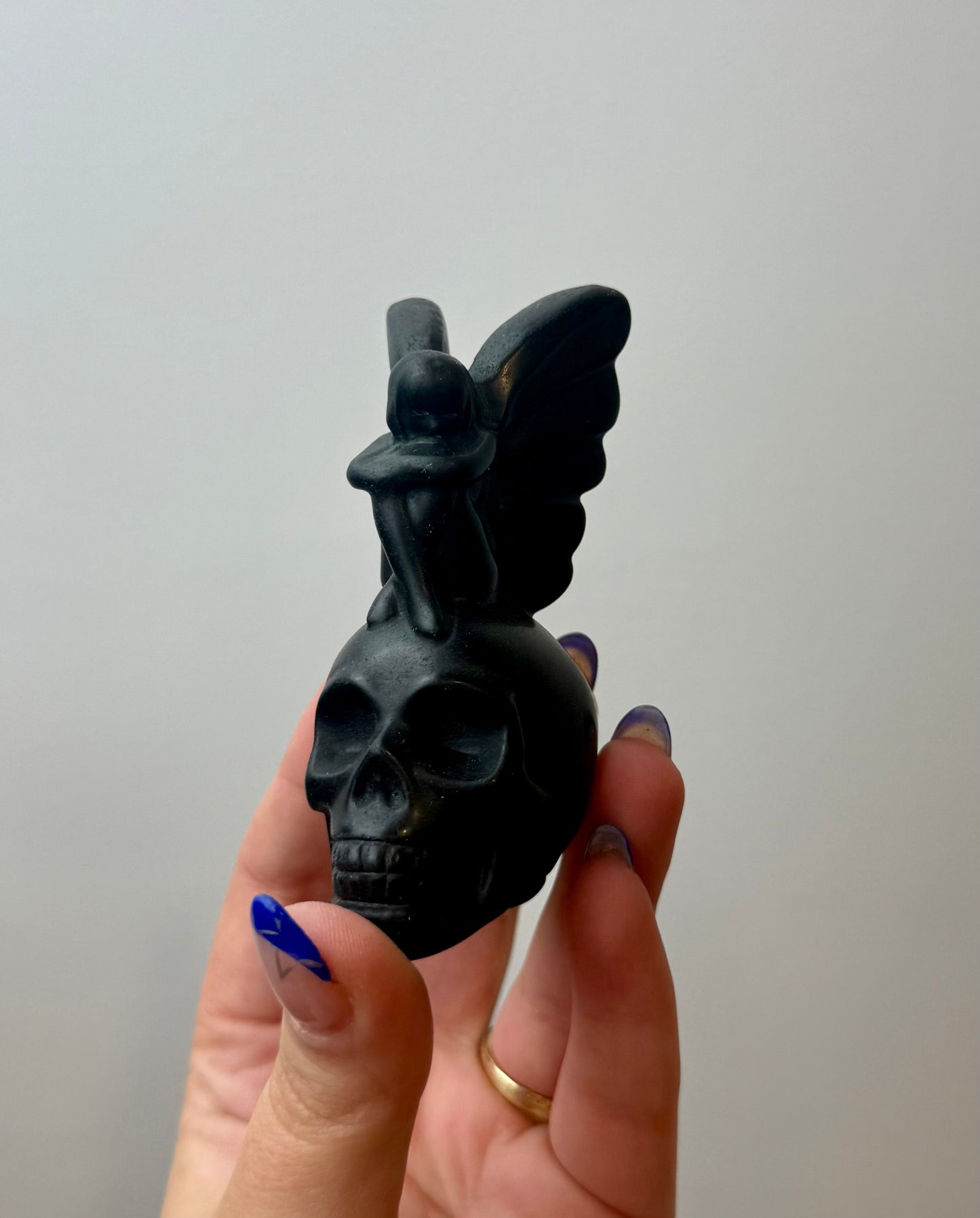 Obsidian fairy on skull carving