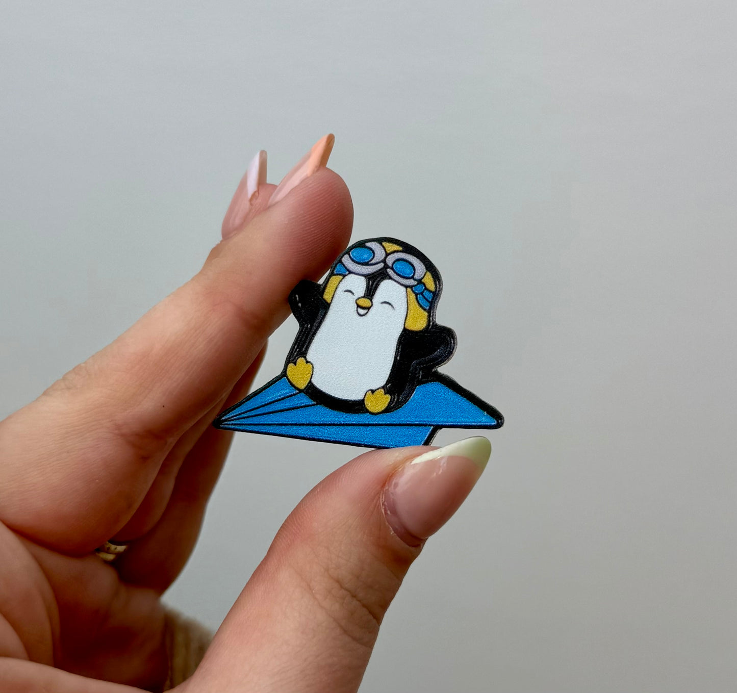 Penguin paper airplane pin