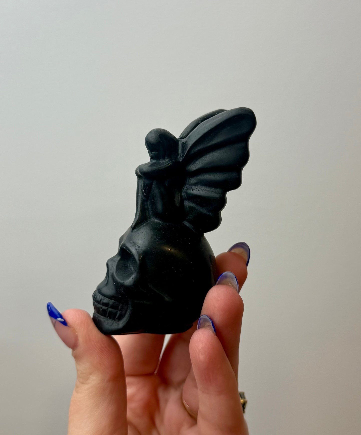 Obsidian fairy on skull carving