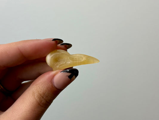 Orange calcite raven head carving