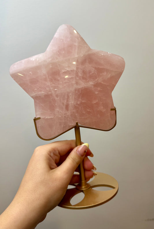 Giant rose quartz star carving on a stand