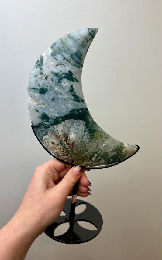 Moss agate moon carving on a stand