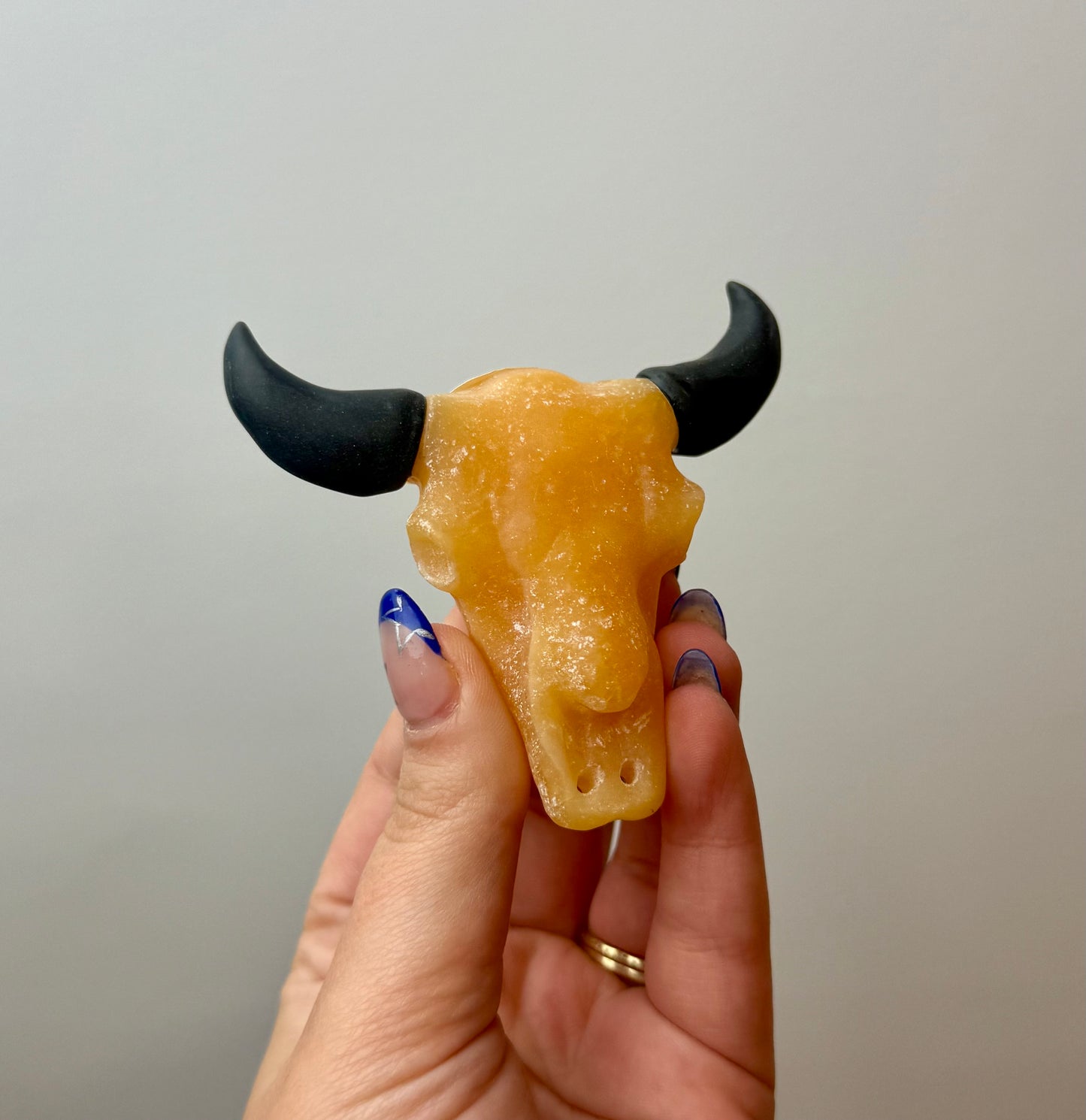 Orange calcite cow skull carving