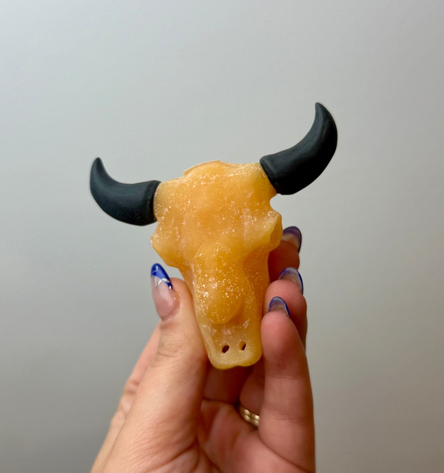 Orange calcite cow skull carving