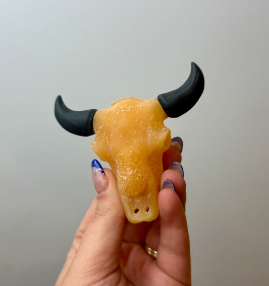 Orange calcite cow skull carving