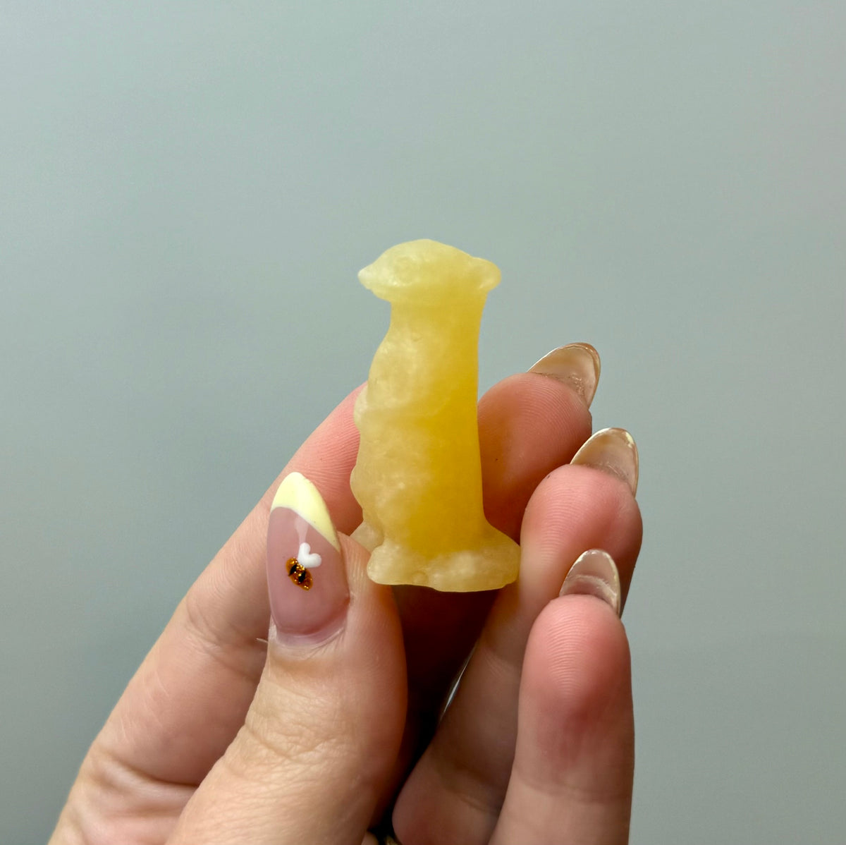 Orange calcite meerkat carving