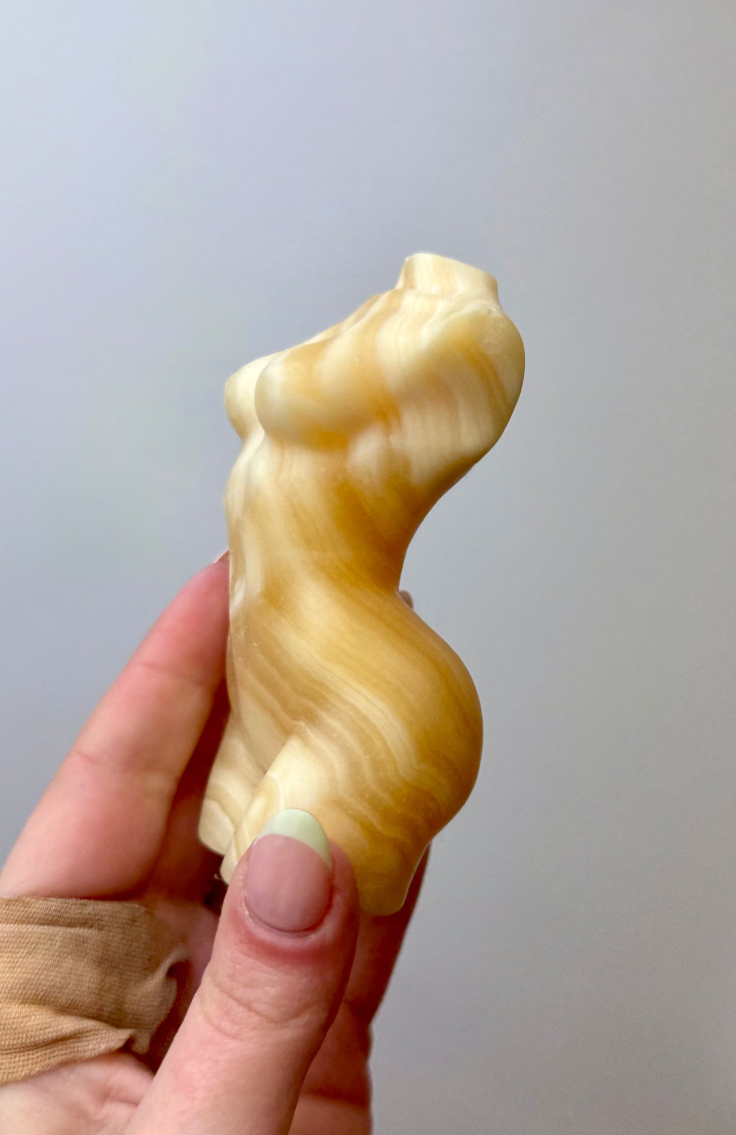 Orange calcite woman body carving