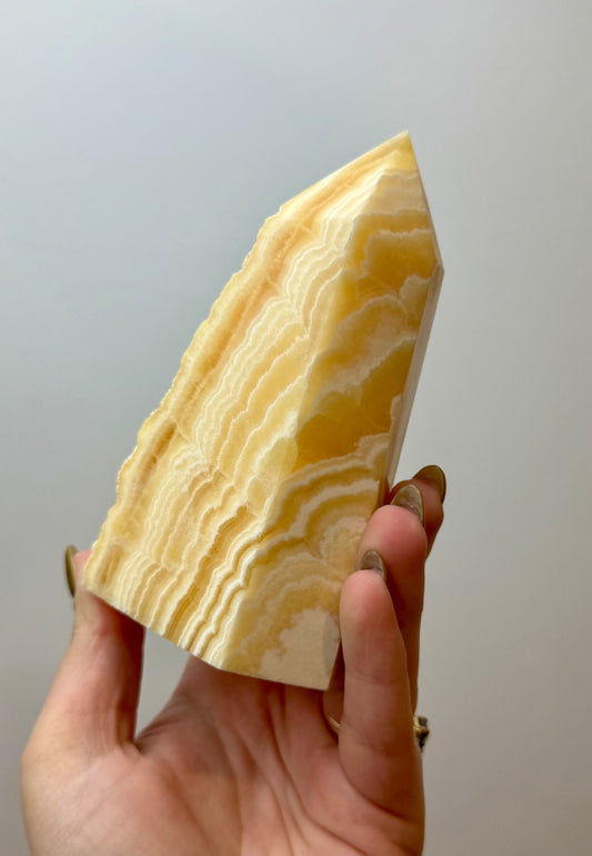 Half raw orange calcite tower