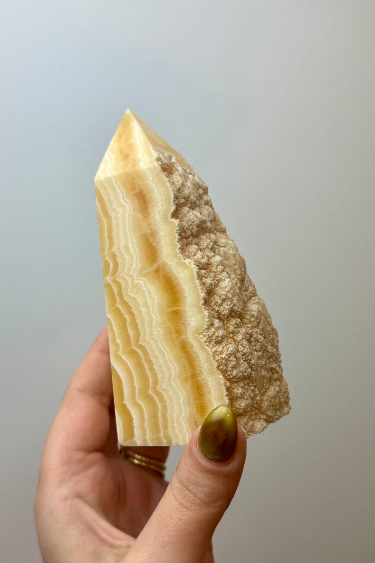 Half raw orange calcite tower