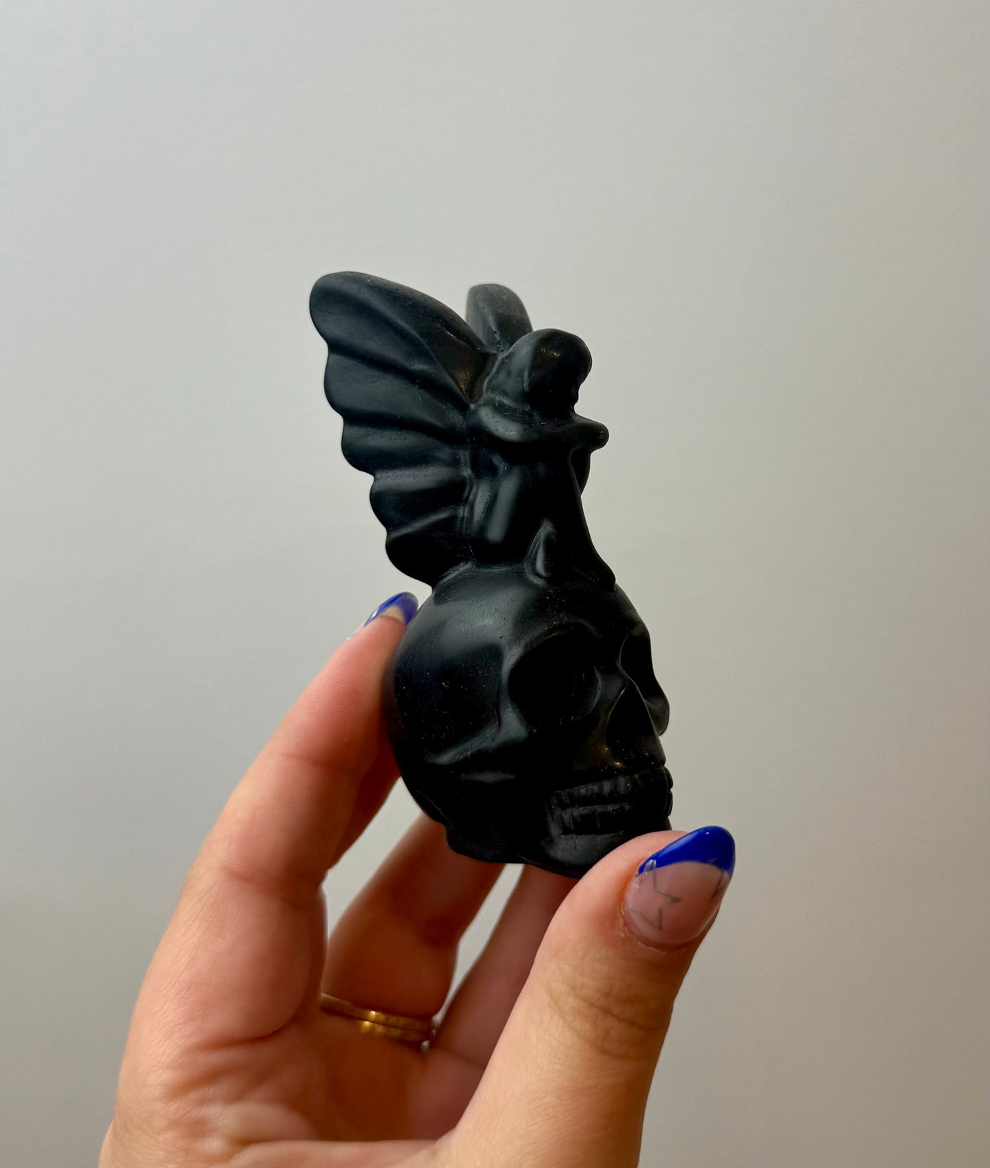 Obsidian fairy on skull carving
