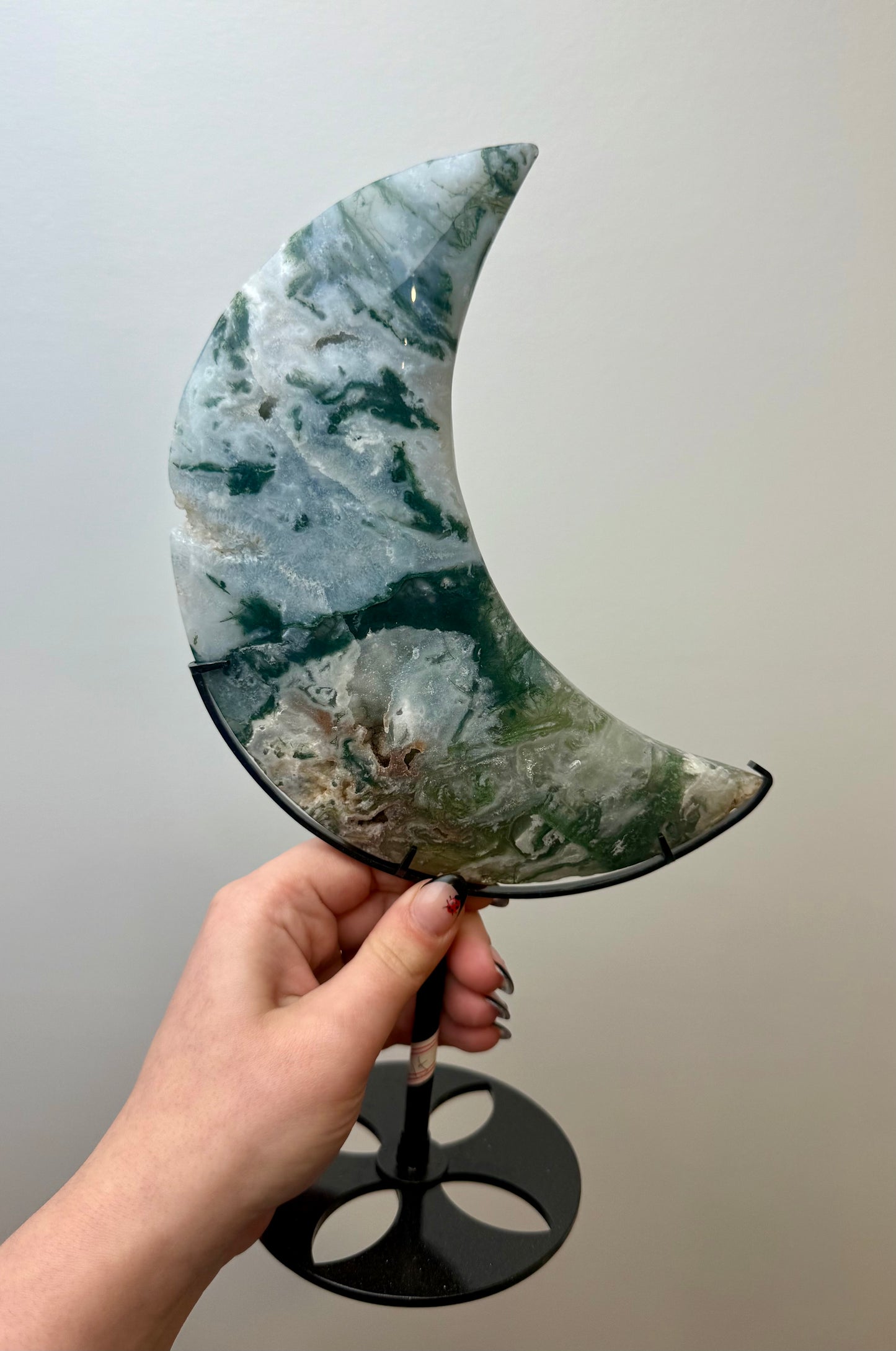Moss agate moon carving on a stand