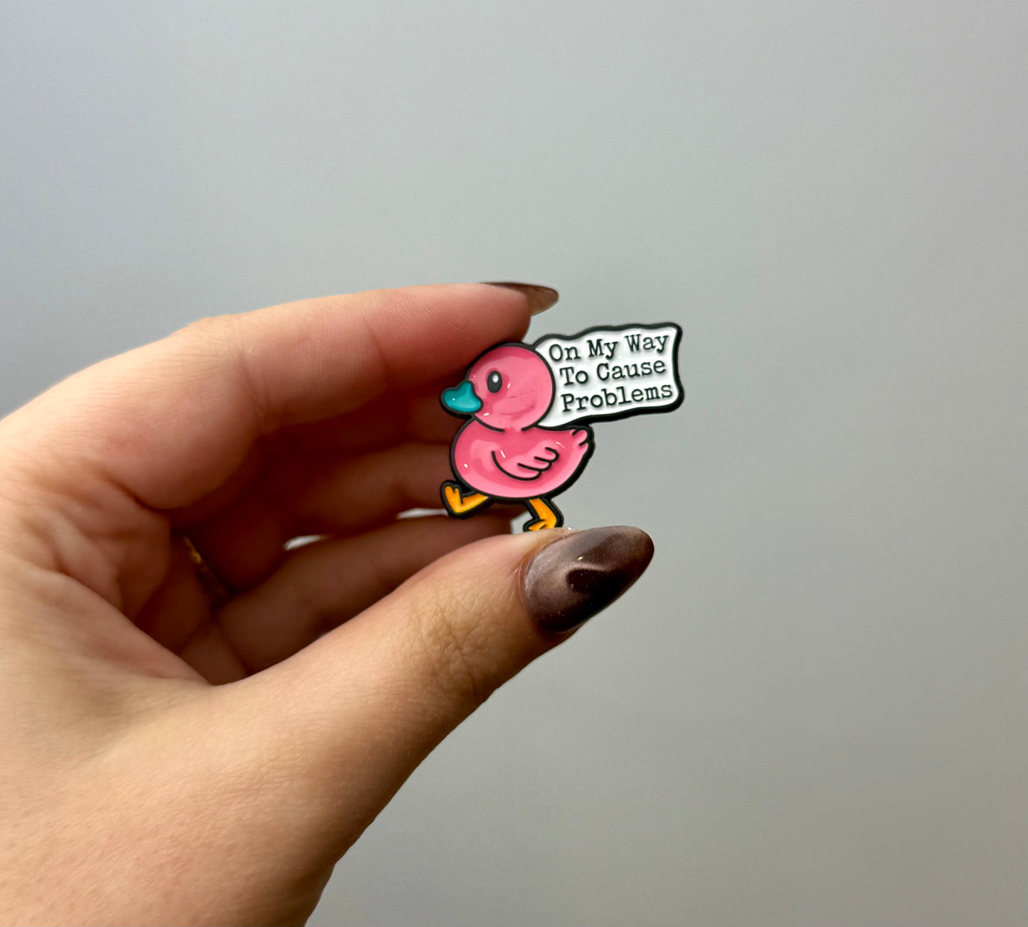 Off to cause problems duck enamel pin