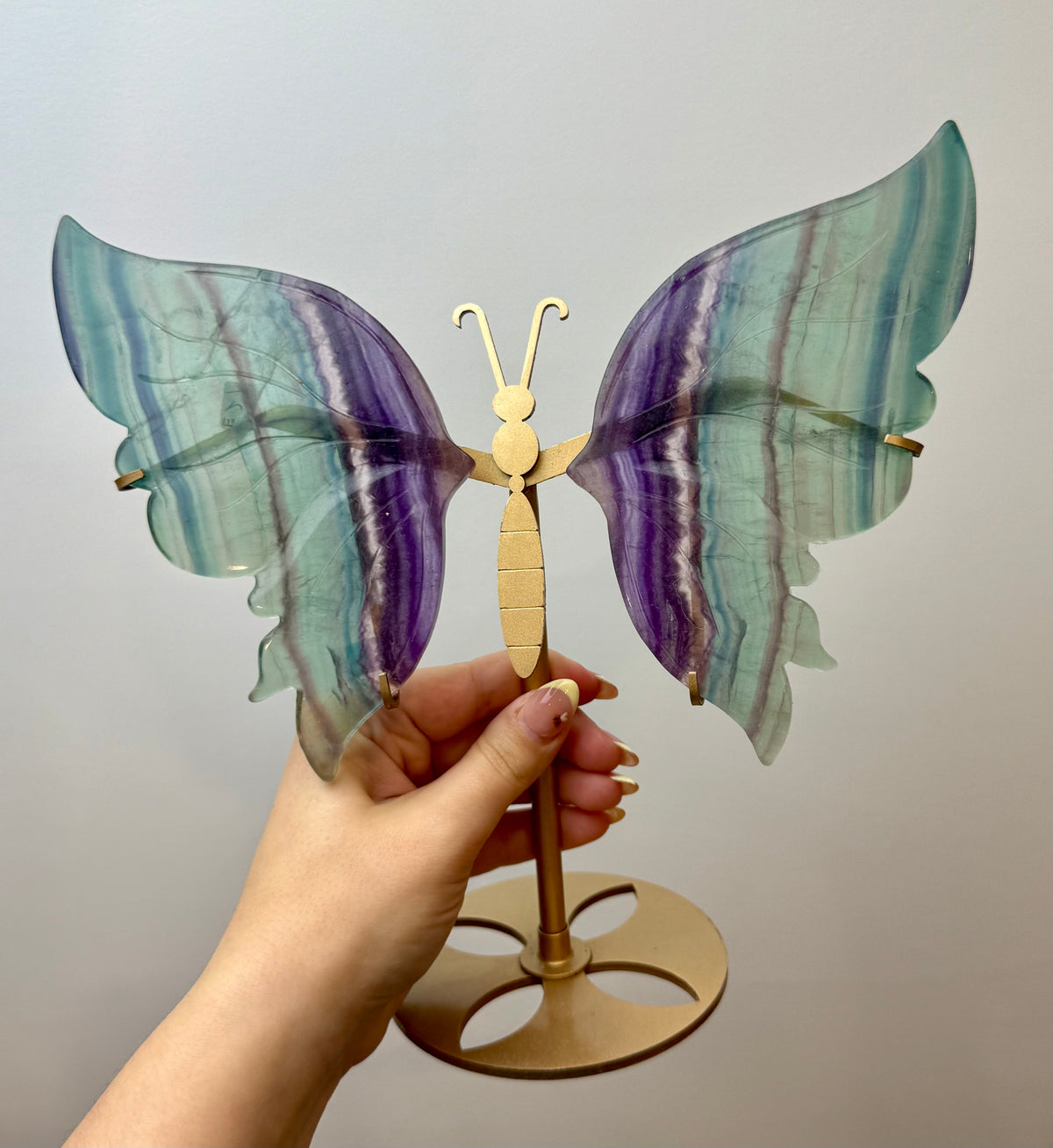 Repaired fluorite butterfly carving on a stand
