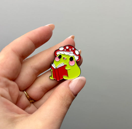 Frog reading a book enamel pin