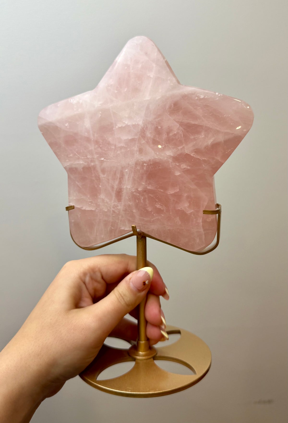 Giant rose quartz star carving on a stand